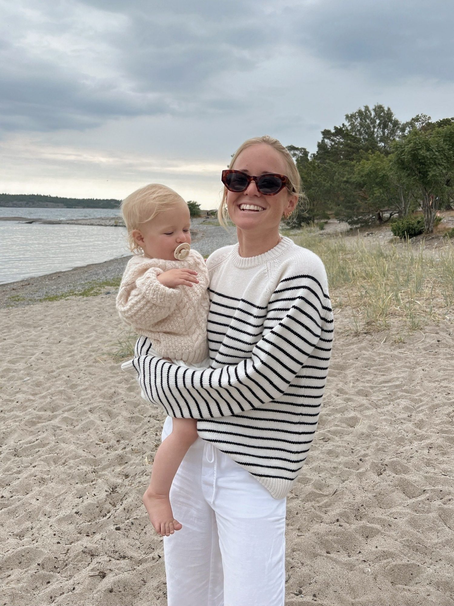 Emma på stranden med barnet sitt