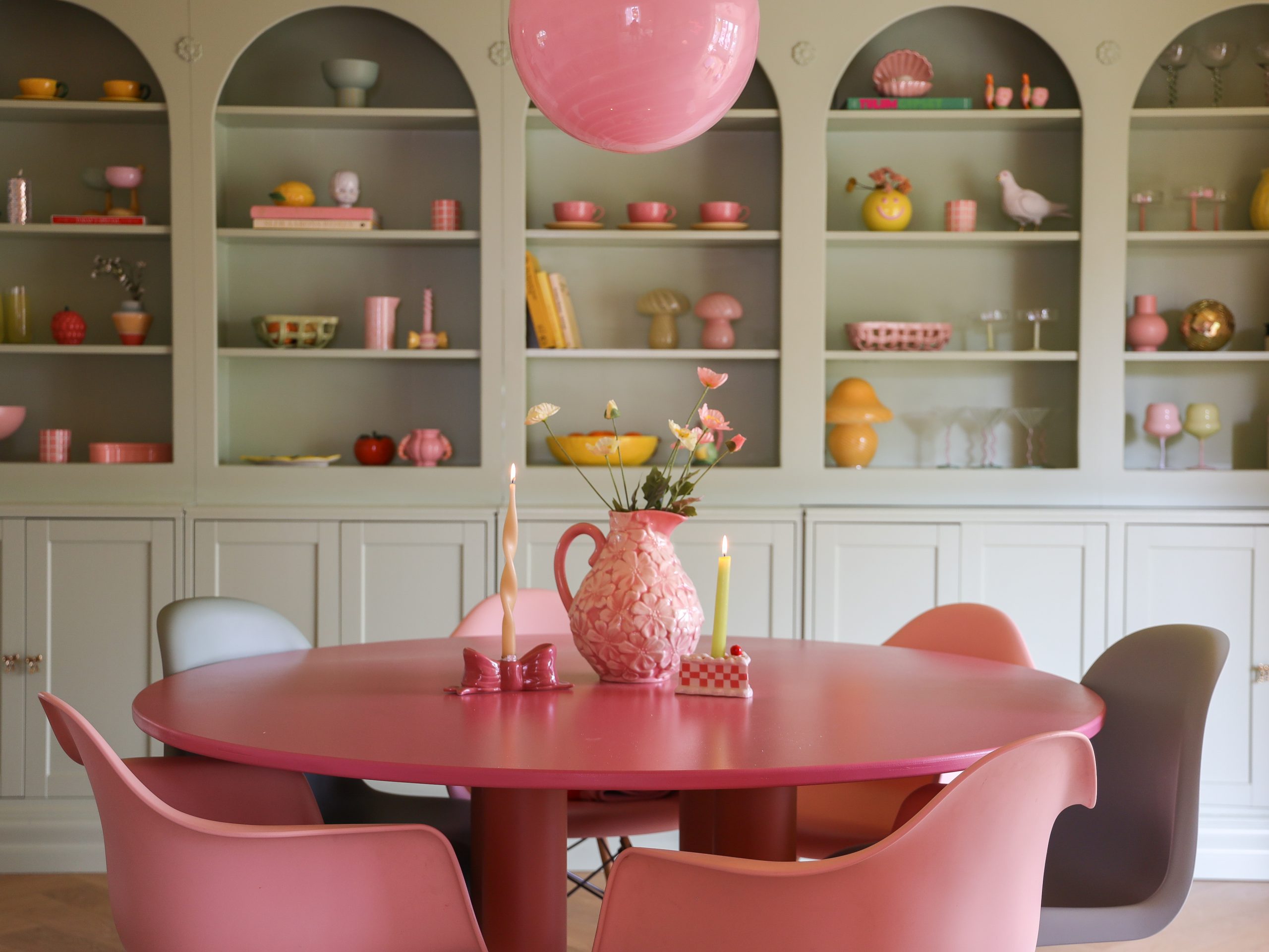 Spisestue med rosa møbler og grønn hylle. Malt hyllevegg: 7386 Pistachio