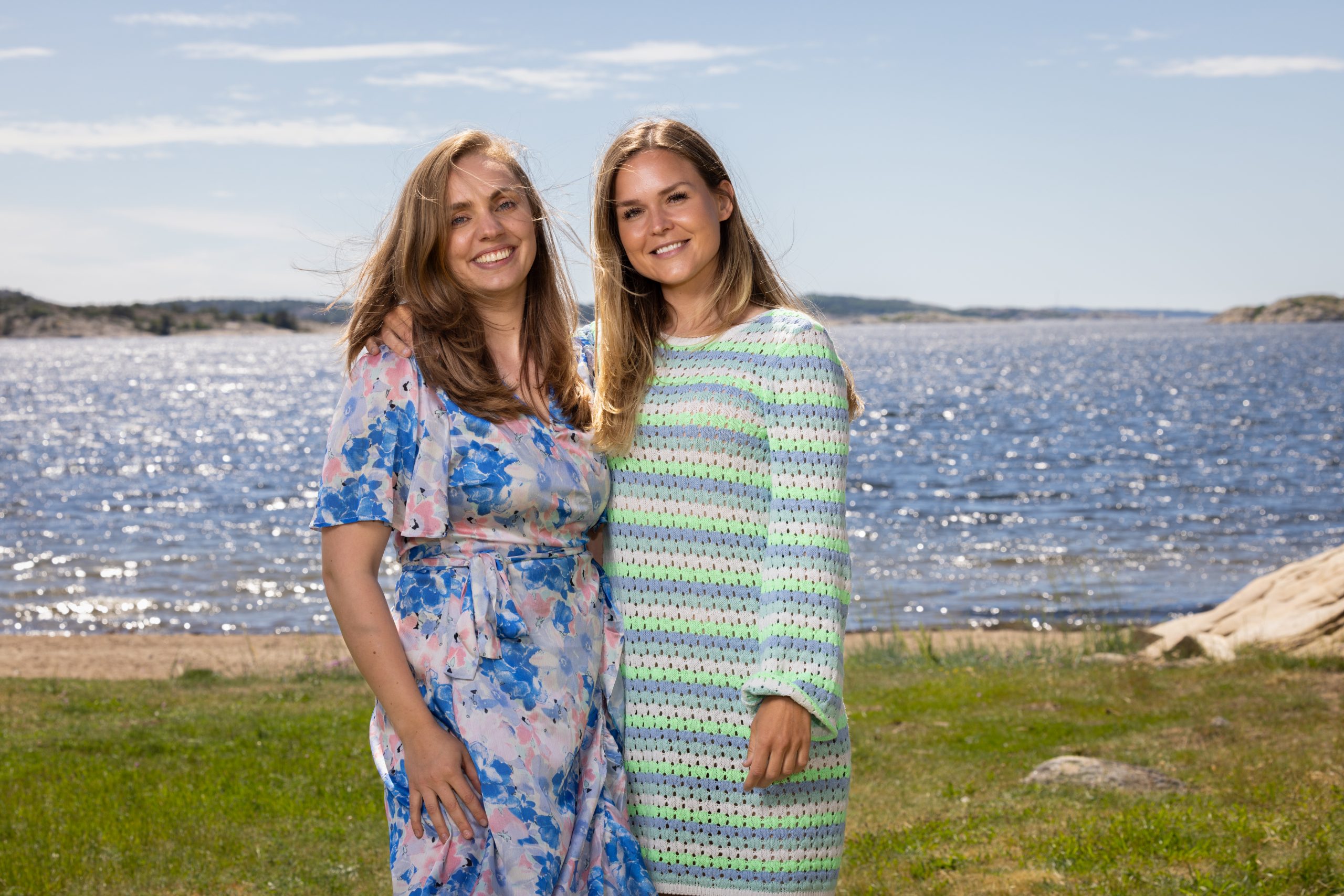 Venninnene Linda og Dina poserer foran havet.