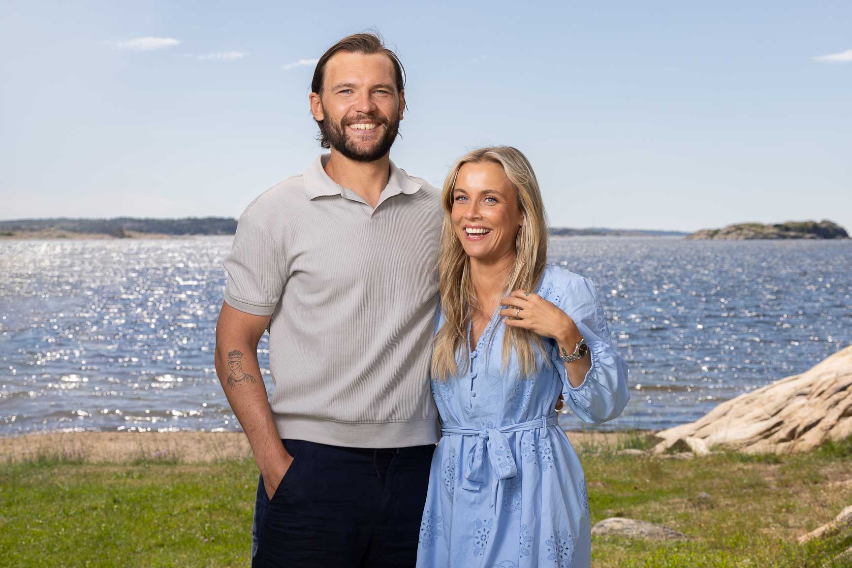 Kjærestepar poserer foran havet.